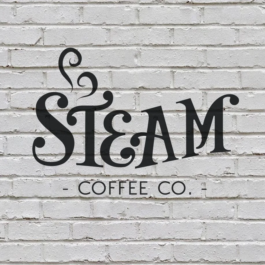 Steam Coffee Co. logo on white brick wall